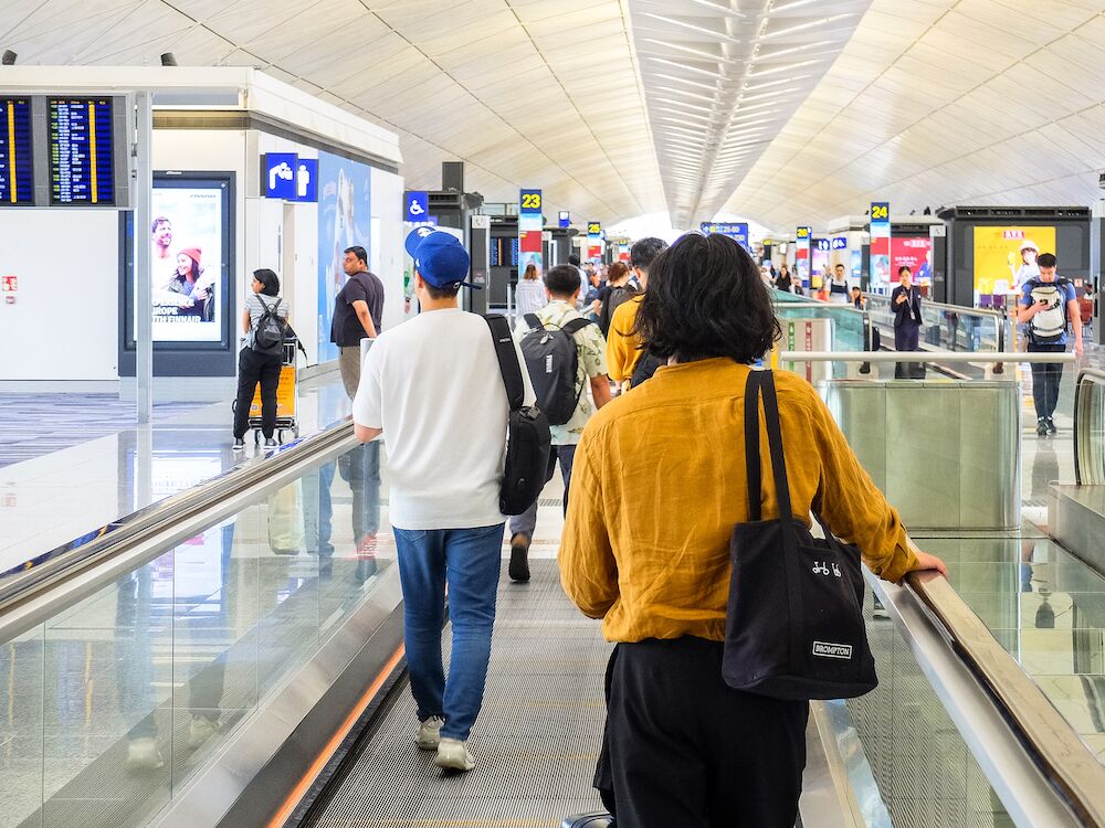 People walking on a moving walkway in an airport