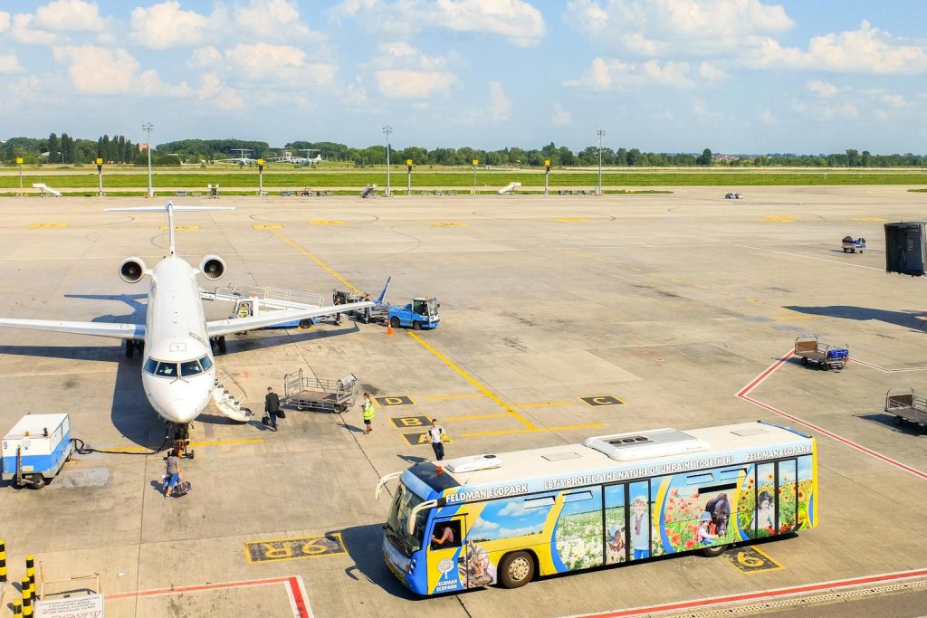 An airplane and a servicing bus on a tarmac