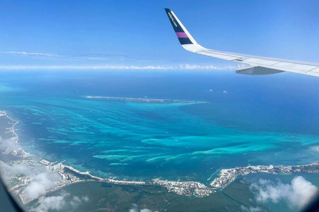 Plane flying over Cancun beach