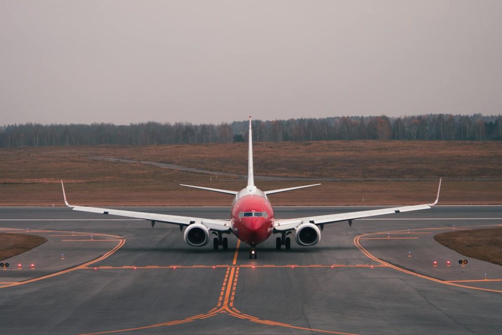 Red and white airplane on a tarmac