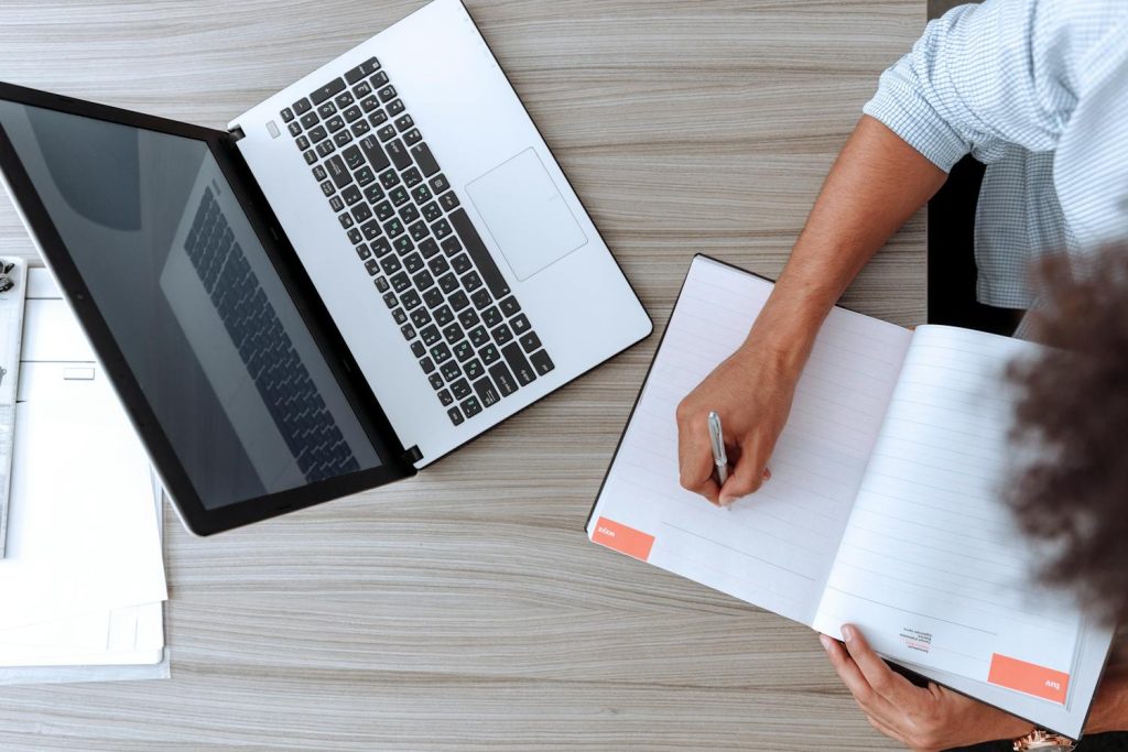 A woman with a laptop and notebook